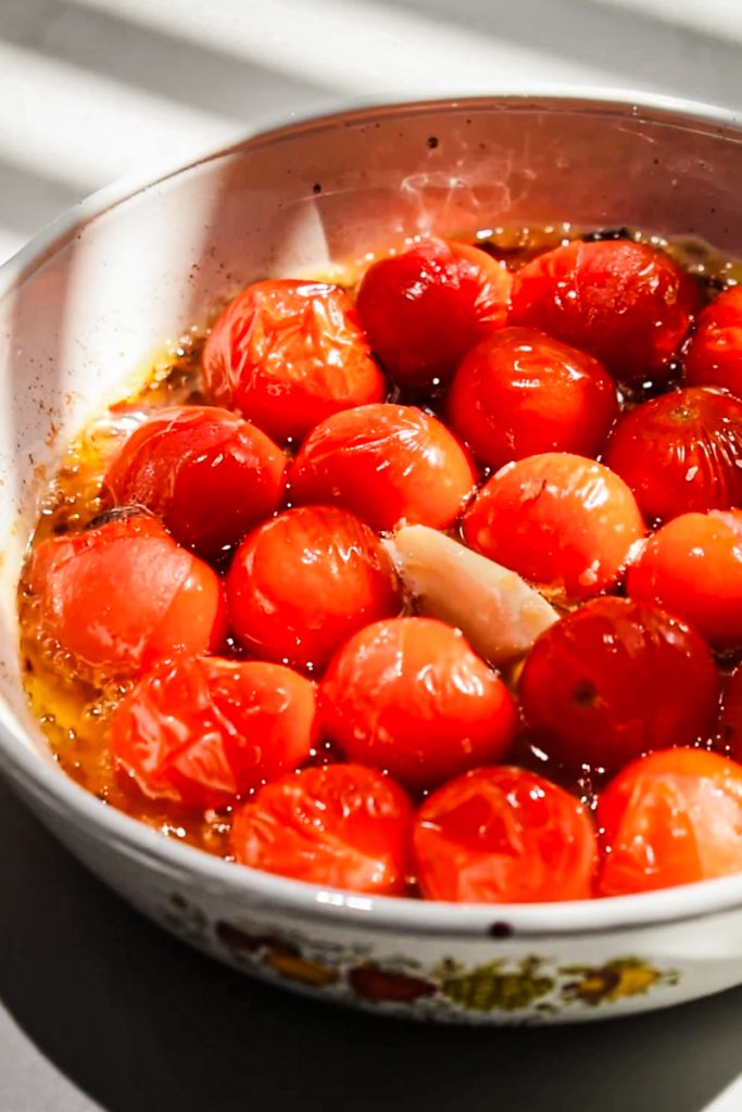 Baked tomatoes in olive oil in a small baking dish.