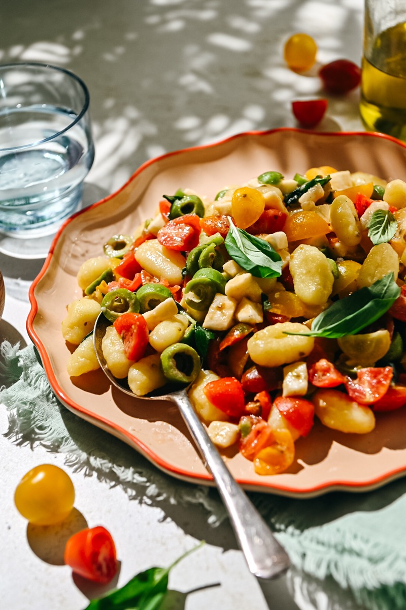 Close side view of summer gnocchi salad on a plate.