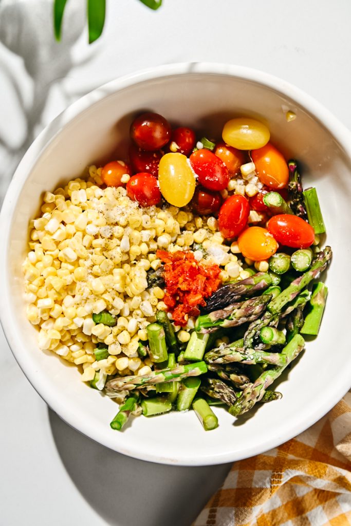 Corn, tomatoes and asparagus in a bowl.
