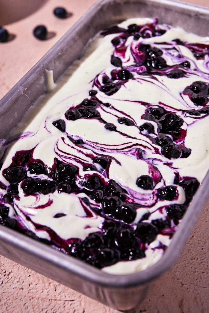 Blueberry mixture swirled into the basil ice cream mixture in a loaf pan.