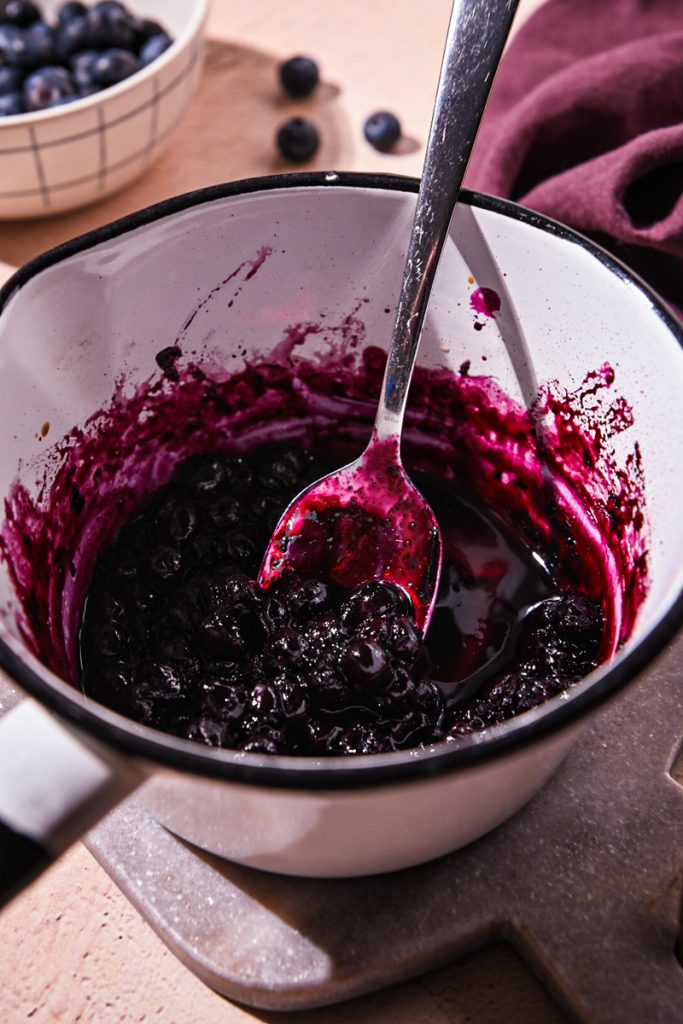 Cooking blueberries, balsamic and honey in a saucepan.