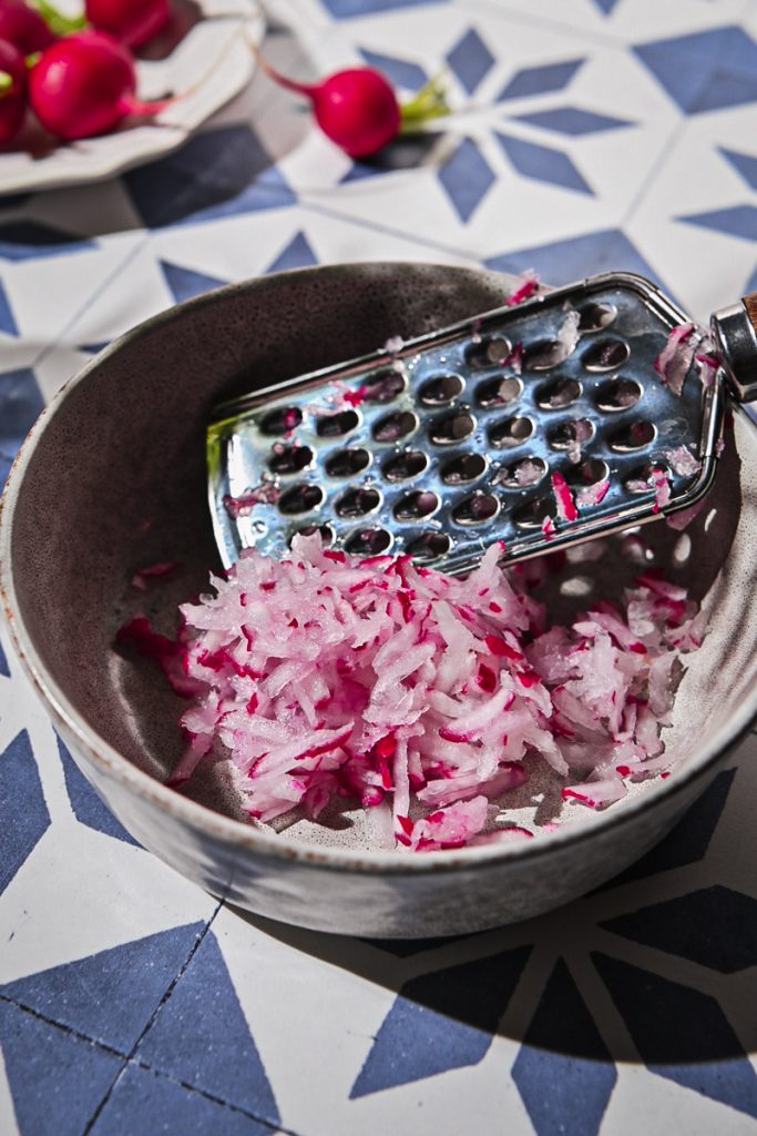 Grated radishes in a small bowl.