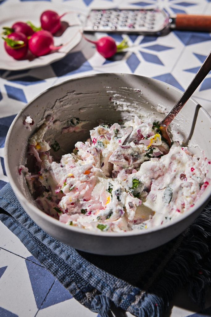 Mixing together the ricotta radish dip in a small bowl.