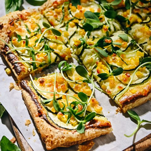 Sliced zucchini tart garnished with microgreens.