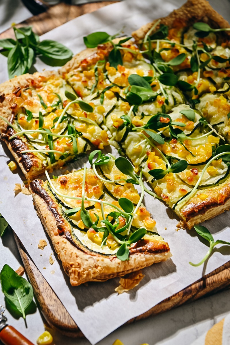 Sliced zucchini tart garnished with microgreens.