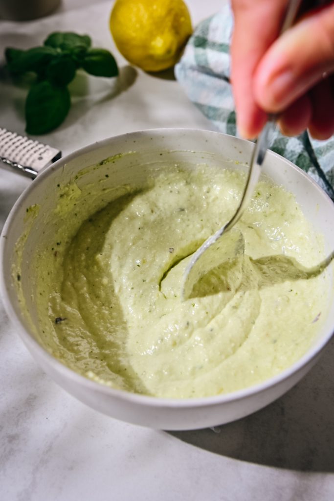 Ricotta mixed with pesto in a bowl.