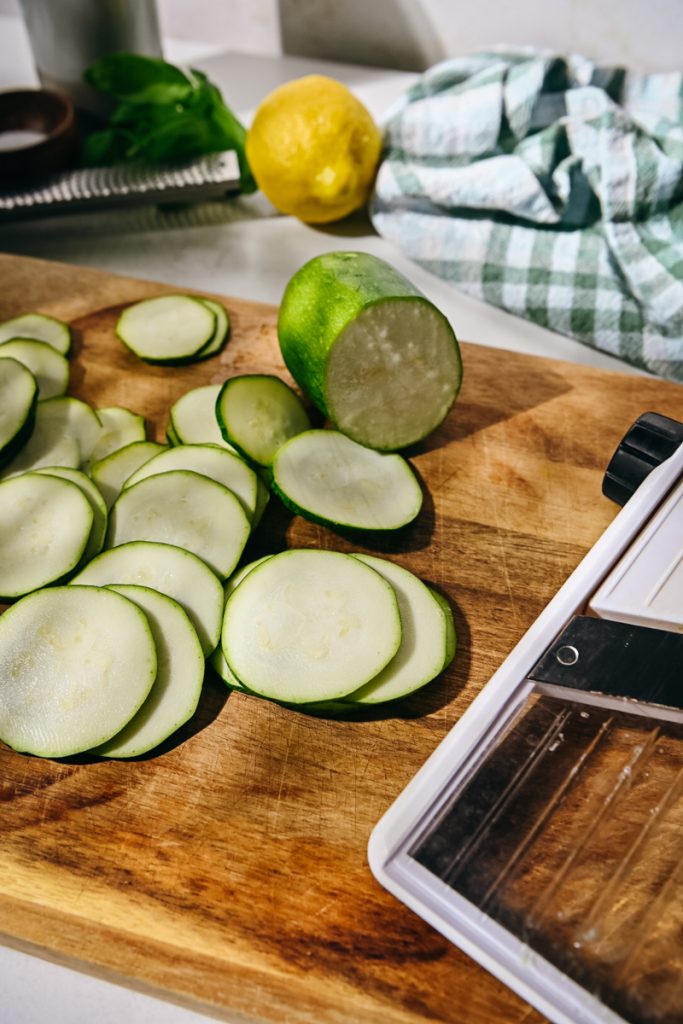 Slicing zucchini on a mandoline.