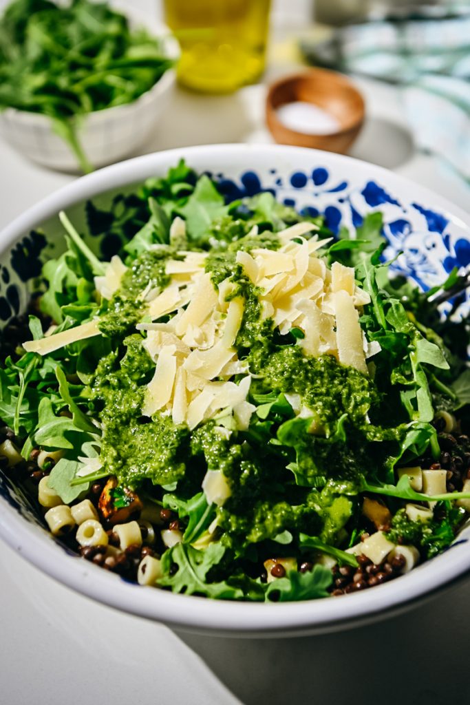 Arugula, dressing, and parmesan added to the bowl.