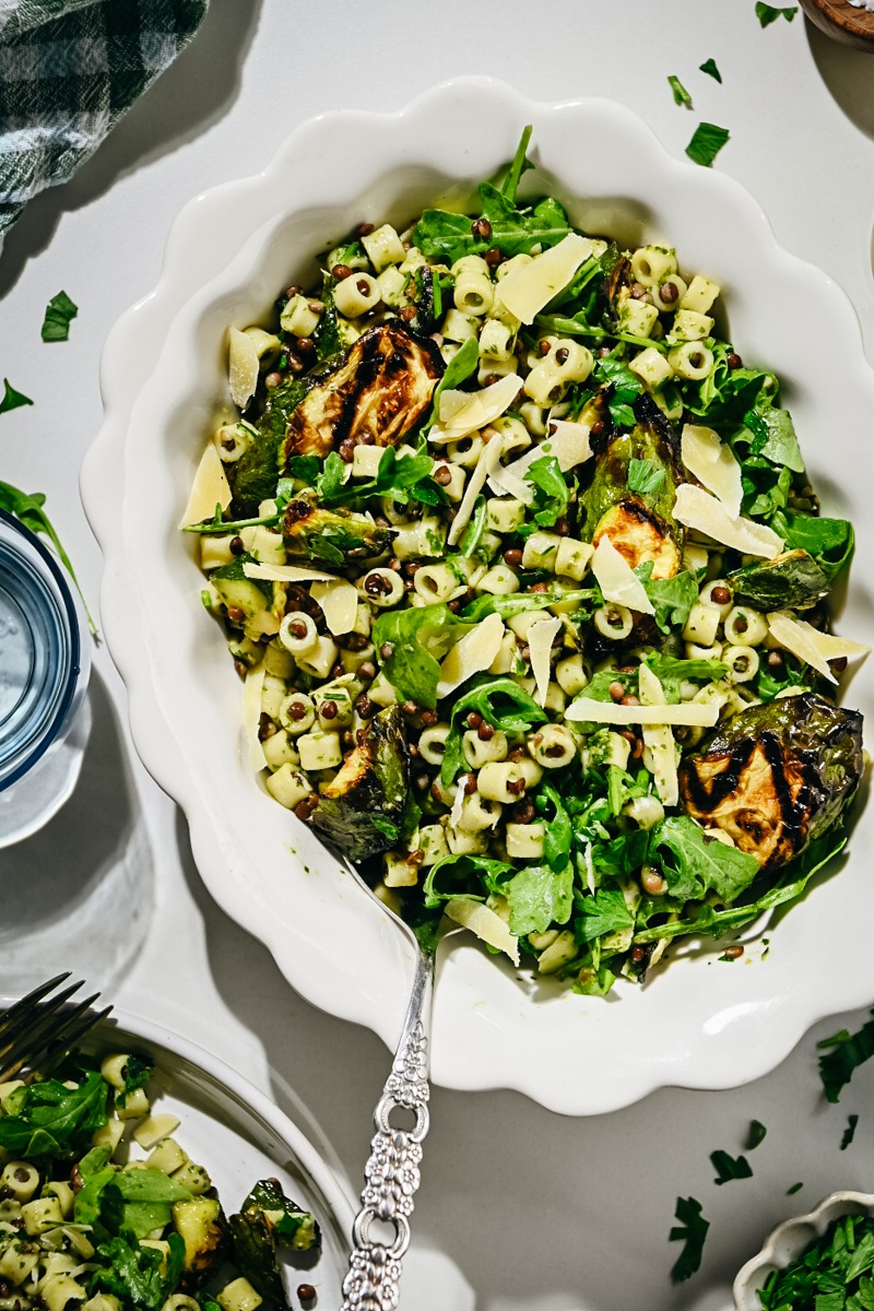 Herby zucchini pasta salad with lentils served in a white serving bowl.