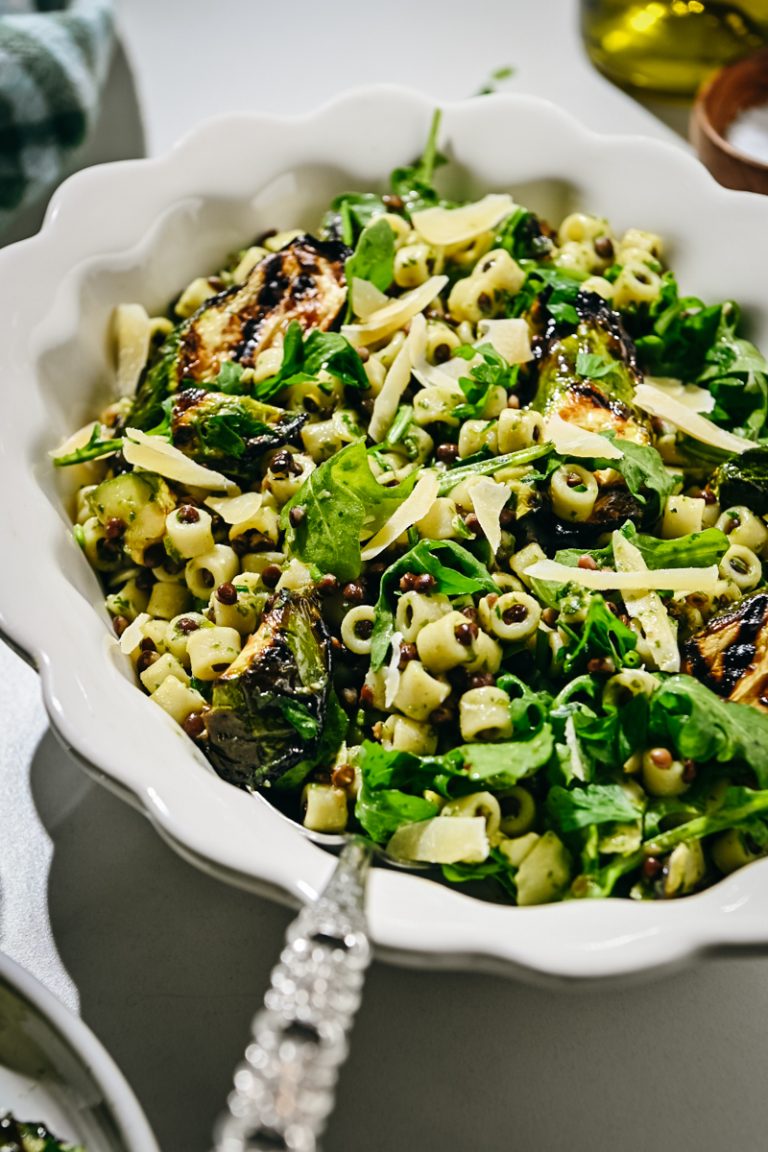 Side view of a zucchini pasta salad served in a white bowl.