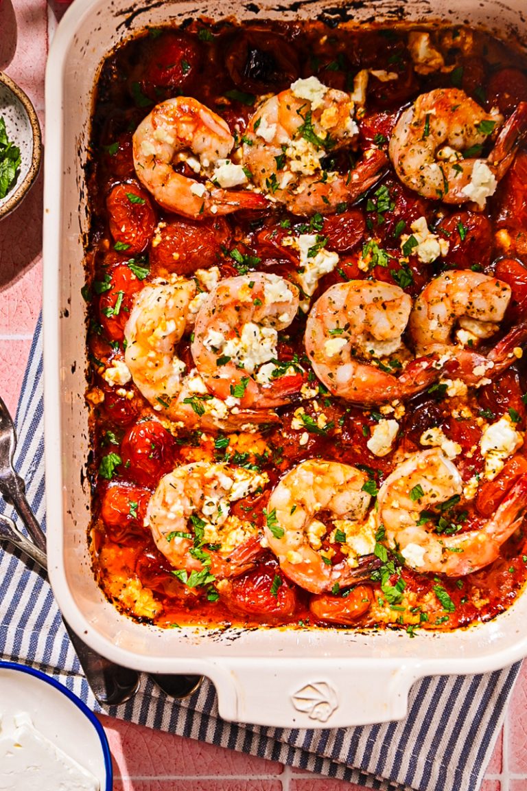 Shrimp saganaki in a baking dish, topped with feta and parsley.