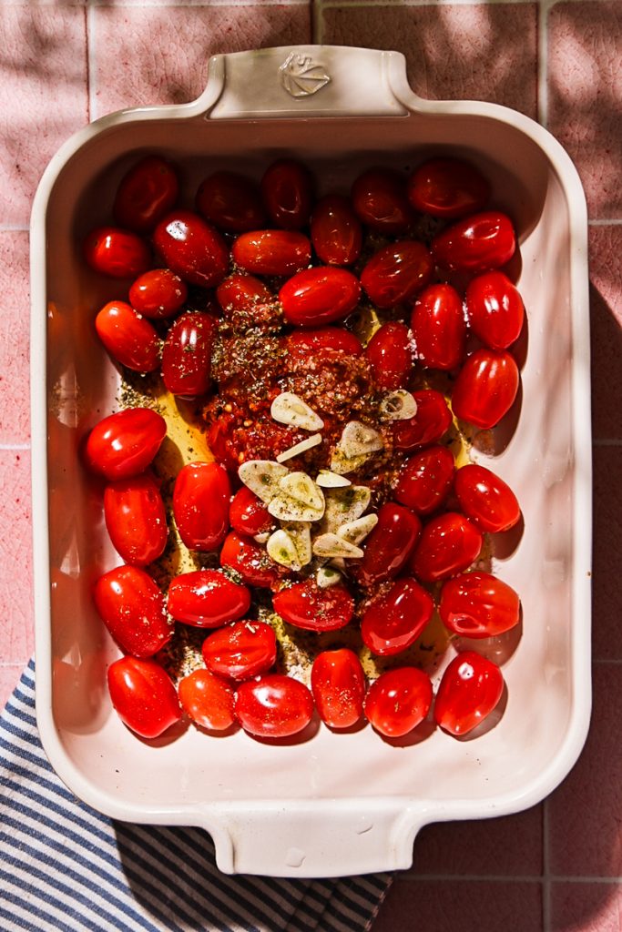 Grape tomatoes with garlic, olive oil and Calabrian chili in a baking dish.