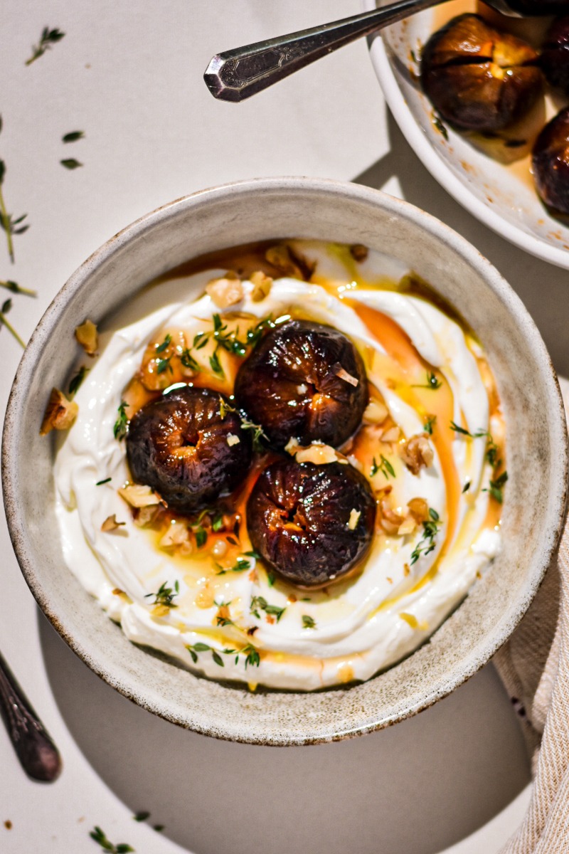 Overhead shot of roasted figs with yogurt in a bowl.