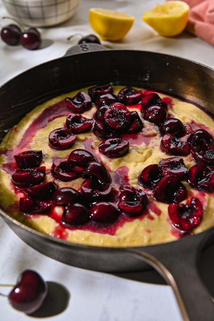 Cherry mixture topped over the top of the batter in a cast iron skillet.