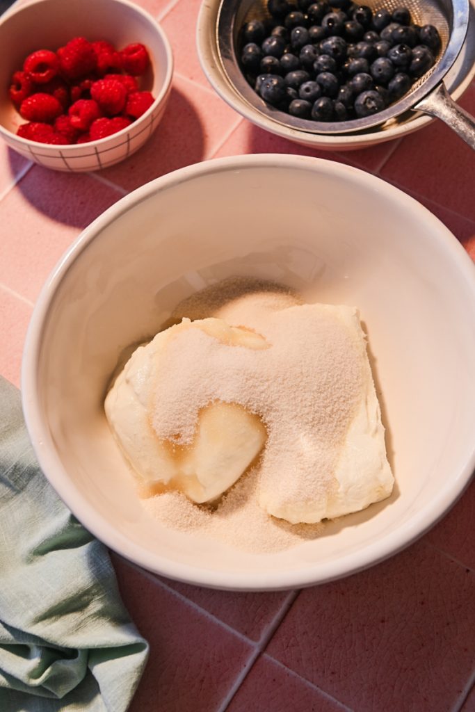 Cream cheese, yogurt and sugar in a bowl.