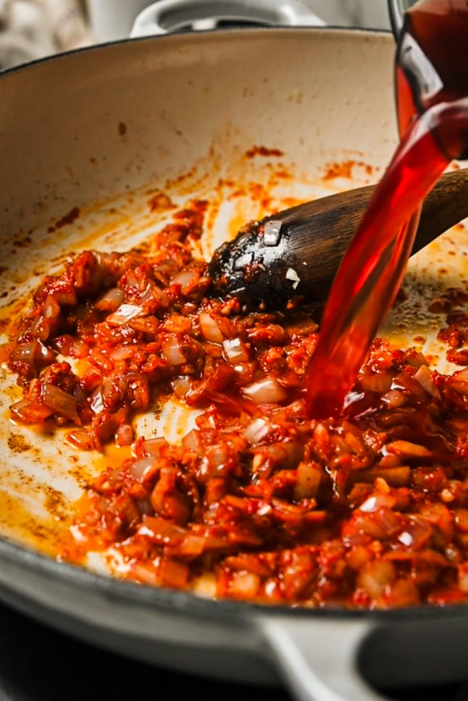 Tomato paste and red wine vinegar added to the skillet.
