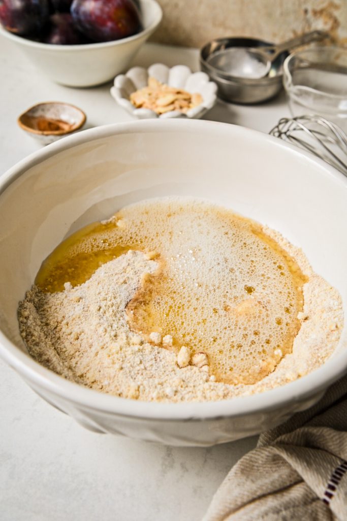 Egg whites added into the dry ingredients in a mixing bowl.