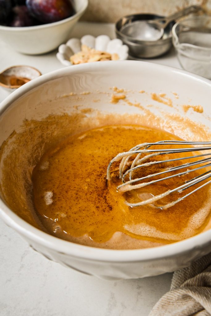 Brown butter added into the batter in a mixing bowl.