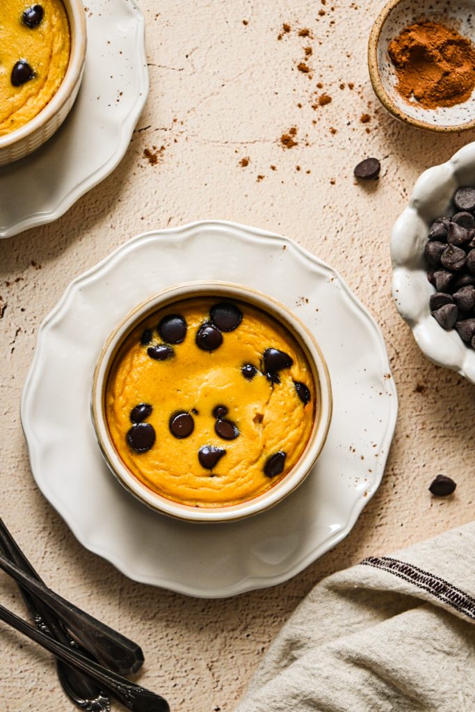 Overhead view of pumpkin banana baked yogurt with chocolate chips on a white plate.